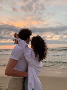 a man and woman embracing on the beach