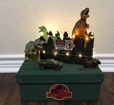 a toy dinosaur and other toys are in a box with lights on the top, along with a sign that says dino zoo