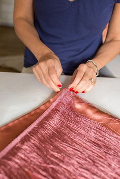 a woman is cutting fabric on a table