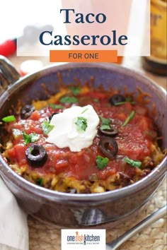 taco casserole with sour cream and olives in a bowl on a table