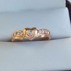 This is a beautiful 18ct solid warm yellow gold diamond ring . The center heart shaped diamond gemstone measures approx 2.0mm.  The 6 x side of diamonds measure approx 1.5mm each. These diamonds are quality, clear and have fantastic fire. The heart is not flat but rounded and modern. The center heart shaped diamond has a more subdued twinkle because round cut diamonds have the most brilliance. A sweet quality ring, it is in excellent shiny condition. The ring has no hallmark, but tested guaranteed 18k gold. Weight: 3.2 grams Size (AU)  L  (US ) 5.75 Heart Diamond Ring, Aloe Vera Hair Mask, Diamond Heart Ring, Yellow Gold Diamond Ring, Warm Yellow, Gold Diamond Ring, Heart Shaped Diamond, Puffy Heart, Heart Jewelry