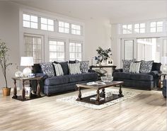 a living room filled with blue couches and chairs on top of a hard wood floor