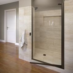 a bathroom with a glass shower door and wood flooring, along with two white towels hanging on the wall