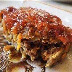 a piece of lasagna on a plate covered in sauce and meat, ready to be eaten