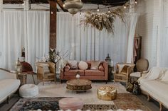 a living room filled with lots of furniture next to a white drape curtained window