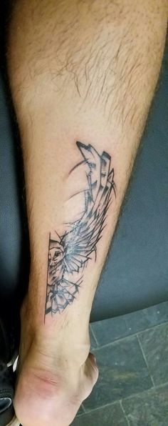 a man's foot with a tattoo design on the side of his left leg