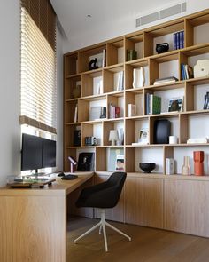 a desk with a computer on it in front of a bookshelf