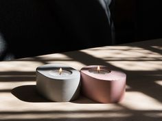 two candles sitting on top of a wooden table