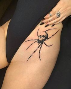 a woman's thigh with a spider tattoo on her lower half and the top part of her leg