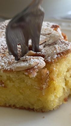 a piece of cake with powdered sugar on top and a fork in the middle