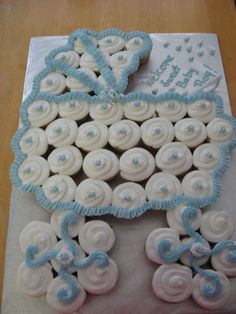 a baby carriage cake with blue icing and white frosting on the top is sitting on a table