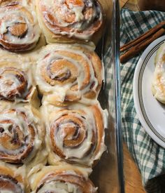 cinnamon rolls with icing sitting on top of a table