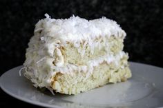 a close up of a piece of cake on a plate with the rest of it covered in frosting