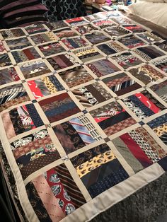 a bed with a quilt made to look like ties on it