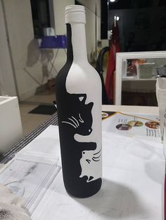 a black and white cat painted on a wine bottle