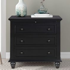 a black dresser with two vases on top of it