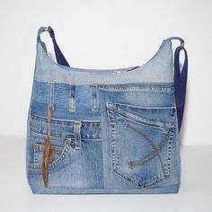 a purse made out of blue jeans with gold hardwares and zippers on the side