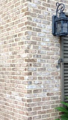 a brick building with an open window and shutters