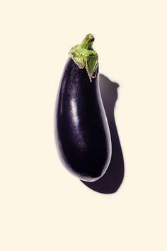 an eggplant is shown on a white background with shadow from the top down