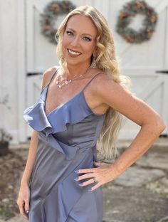 a woman in a gray dress posing for the camera