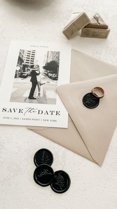 an envelope, two wedding rings and some magnets on a table with a photo