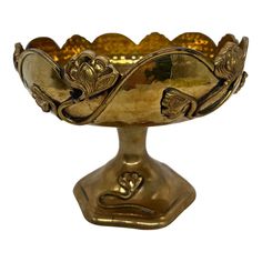 a gold colored bowl with ornate designs on it