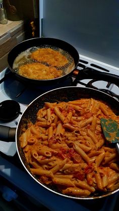 two pans filled with pasta sitting on top of a stovetop next to each other