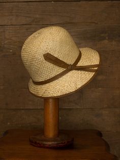 "An authentic antique woven cloche from the late 1920s or 30s era. Originally acquired by a European hat shop that closed in the 1930s. Made from a light colored woven straw with a simple yet elegant brown wax coated ribbon and buckle. Only minor signs of age from storage, never been previously used. Centimeter measurements written on the inside of the crown by the hat maker. material : straw color : brown, light beige condition : little to no wear, has never been used size : please review measu Fitted Vintage Brown Panama Hat, Vintage Fitted Brown Panama Hat, Adjustable Curved Brim Gatsby Hat, Gatsby Style Adjustable Hat With Curved Brim, Adjustable Gatsby Hat With Curved Brim, Vintage Brown Brimmed Panama Hat, Vintage Brown Panama Hat With Curved Brim, Vintage Brown Adjustable Panama Hat, Adjustable Cloche Hat In Flapper Style