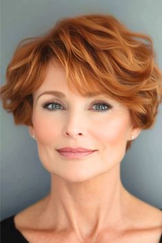 Wavy Pixie Hairstyle on a smiling woman in her 50s with short copper hair.