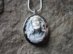 a necklace with an image of a man on it sitting on top of a rock