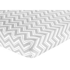 a baby crib sheet with white and grey chevrons on the bottom half