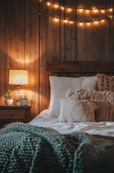 a bed in a bedroom with lights on the wall above it and a night stand