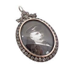 This pretty locket dates from c.1900 and represents the garland style so typical of Edwardian era jewels. Condition Report: Excellent - The locket itself is excellent. However, there is a repair to the enamel photograph of the gentleman. The Details... This locket is constructed from silver. It is stamped on the reverse with '925'. It also features a makers mark. However, this is difficult to decipher, as it has become worn over time. The locket is oval in shape and detailed at the top with a bow motif. This bow and the border of the locket is detailed with small, round colourless paste stones. The locket features two original photographs - an enamel portrait of a gentleman in uniform and a paper picture of a woman. The locket measures 4.75cm x 3.25cm. A Short History... This locket is a l 18th Century Jewelry, Picture Of A Woman, Paper Picture, Edwardian Jewelry, Silver Locket, The Gentleman, A Gentleman, Silver Lockets, Edwardian Era