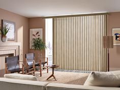 a living room filled with furniture and a large window covered in vertical blind blinds over the windows