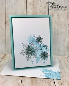 a card with snowflakes on it and the words joy written in blue ink