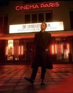 a man standing in front of a movie theater