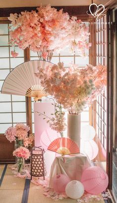 an arrangement of flowers and fan in a room