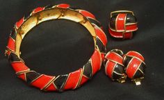 I have never offered a Vendome ring as part of a jewelry parure until now. This vibrant red and black enamel set includes a hinged bangle bracelet, clip earrings, and a 1968 ad piece adjustable ring. The hand applied enamel is in a tomato red and black with raised goldtone edging. The hinged bangle is 5/8 of an inch wide and the inner diameter is 2 1/2 inches. The bracelet would fit a wrist size up to 7 1/4 inches. It closes with a box clasp and has a safety chain. The clip earrings are 1 inch l Bracelet Clip, Black Gold Necklace, Enamel Ring, Earrings Red, Gold Copper, Black Earrings, Hinged Bangle, Enamel Jewelry, Black Enamel