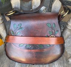 This is a large tooled vintage boho hippie saddle bag shoulder crossbody leather bag...I conditioned the leather, added a new sheen to it and replaced the old cracked lacing with black new lacing and also added a new and long shoulder strap so you can wear this crossbody.... the flap has some painted flowers tooled to it...the flap is secured by the leather strap across the front.. measurements are 9 inches tall, 11 inches across, gusset is 4 inches at the widest part and the new shoulder strap drop is 24 inches. Brown Crossbody Saddle Bag For Festival, Brown Satchel Saddle Bag For Festivals, Bohemian Crossbody Saddle Bag With Adjustable Strap, Bohemian Saddle Bag With Adjustable Crossbody Strap, Bohemian Satchel Saddle Bag With Adjustable Strap, Bohemian Saddle Bag Satchel With Adjustable Strap, Bohemian Hand Tooled Saddle Shoulder Bag, Bohemian Hand-tooled Saddle Shoulder Bag, Bohemian Leather Saddle Satchel Bag