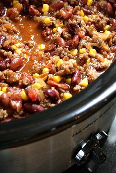 a crock pot filled with chili and corn