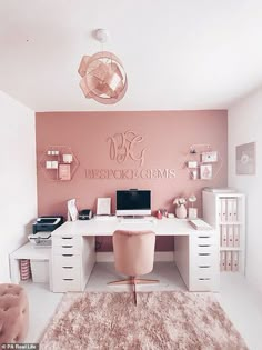 a white desk topped with a laptop computer next to a pink chair and wall art