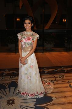 a woman in a white dress standing on a carpet