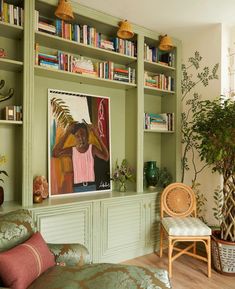 a living room filled with lots of furniture and bookshelves covered in green paint