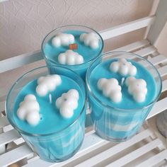 three glasses filled with blue liquid and white marshmallows in the shape of elephants