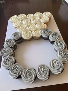 cupcakes arranged in the shape of a heart on top of a card board