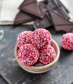 chocolate and sprinkle covered donuts in a bowl