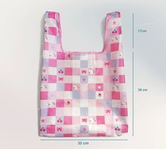 a pink and white checkered shopping bag with hello kitty on it's side