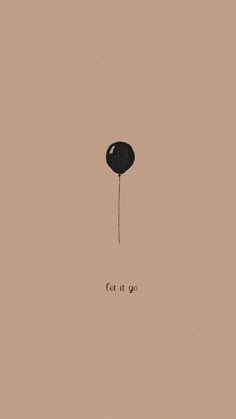 a black balloon with the word let it go written on it's side in front of a pink background