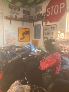 a room filled with lots of clothes and a stop sign on the wall above it