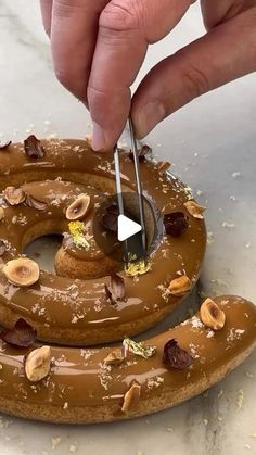 someone is decorating some pretzels with chocolate and nuts